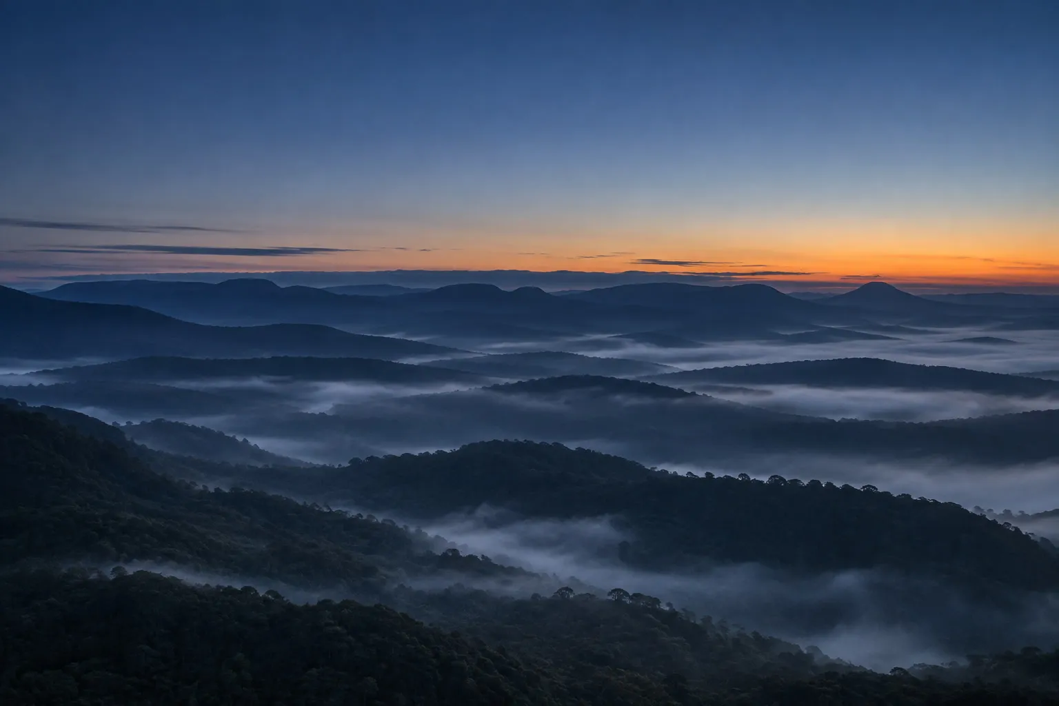 Amanhecer sobre morros com camadas horizontais de névoa no interior de Santa Catarina